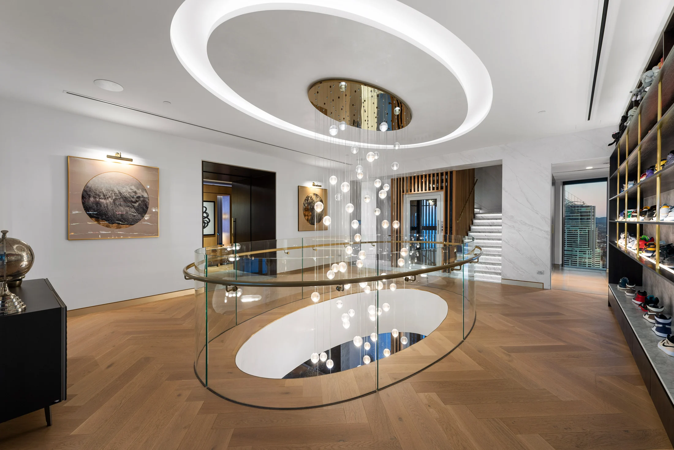 Sculptural chandelier and oval void connecting the penthouse living levels