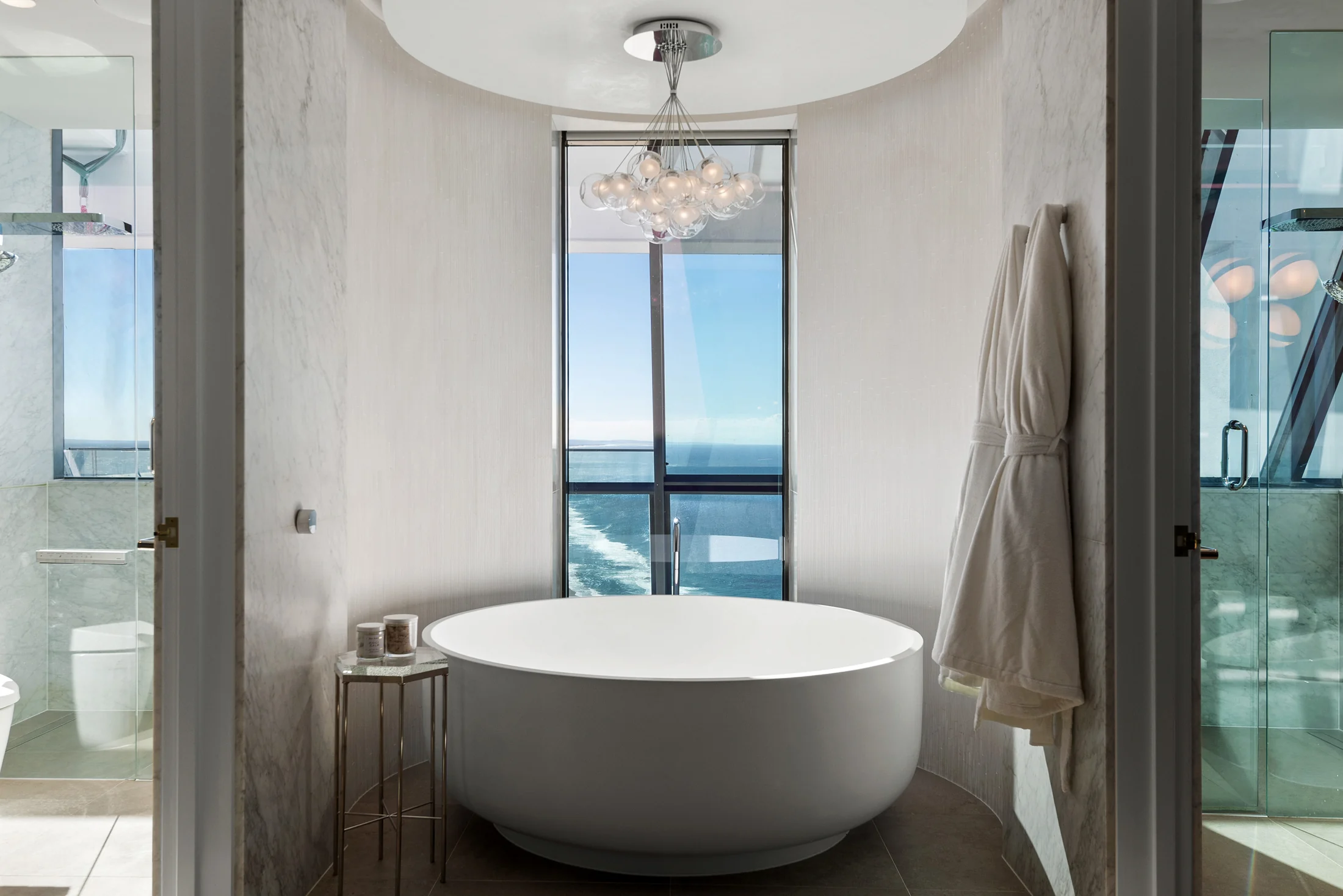 Freestanding bath beside a window with an ocean outlook