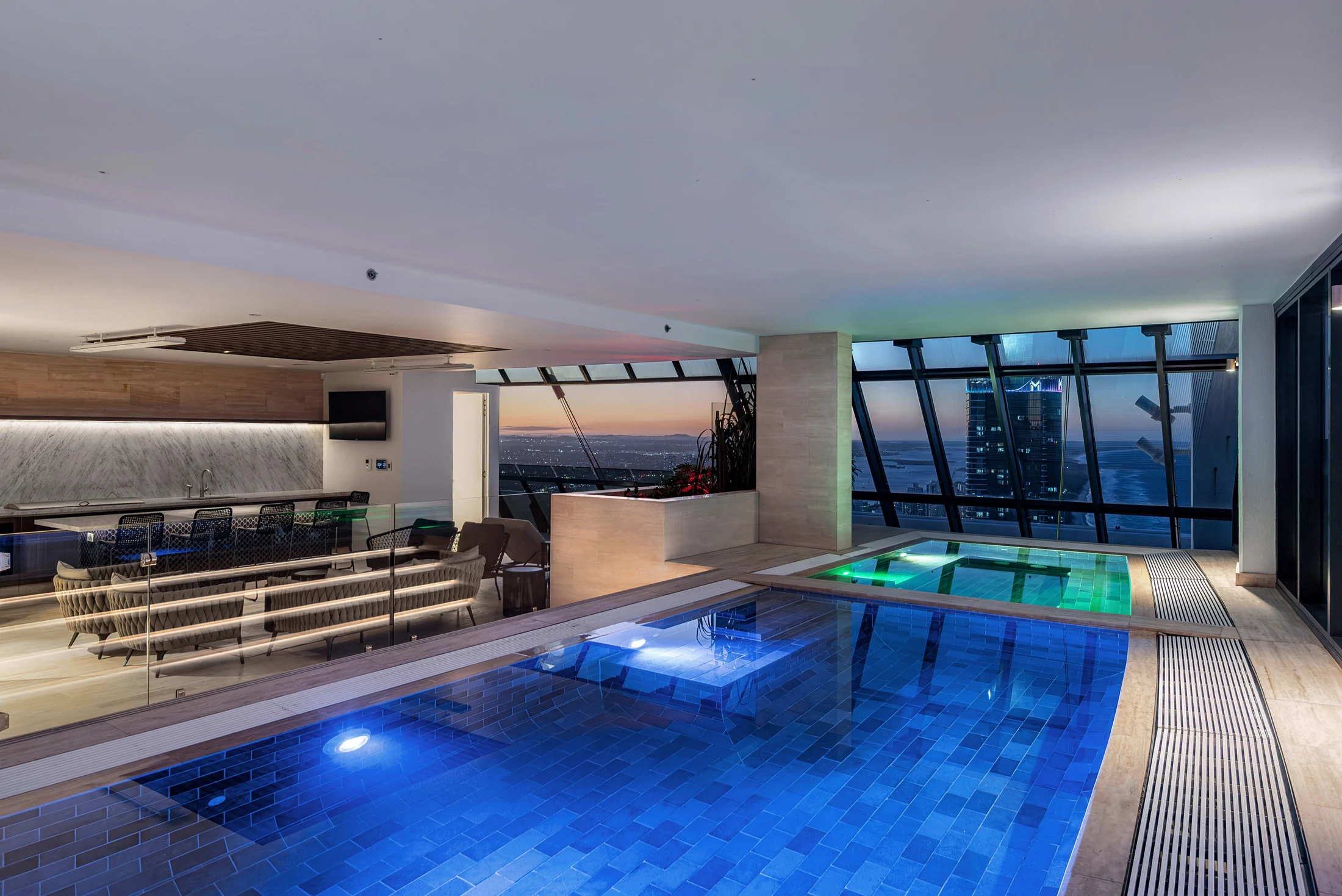 The private rooftop pool glowing blue at night